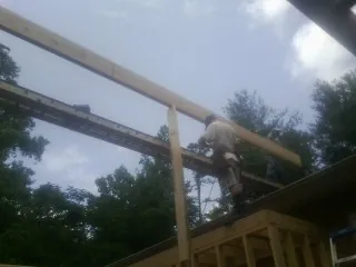 Carpenter setting a ridge beam over a new addition frame — Ice Dam Removal by Roofing Brothers in Mount Hermon