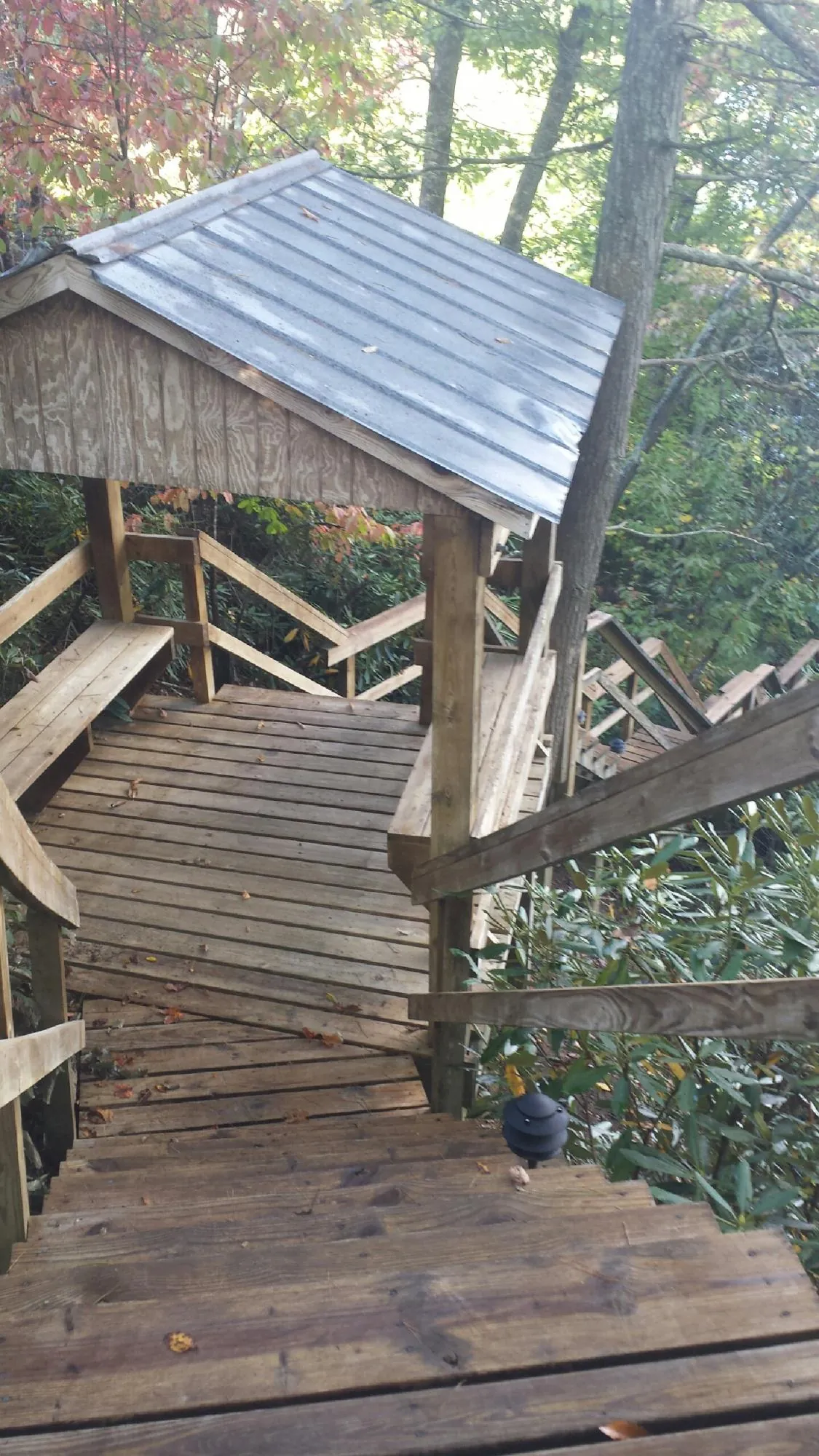 Metal roofed shelter over wooden steps on a wooded walkway — Skylight Repair & Installation work by our crew in Mount Hermon